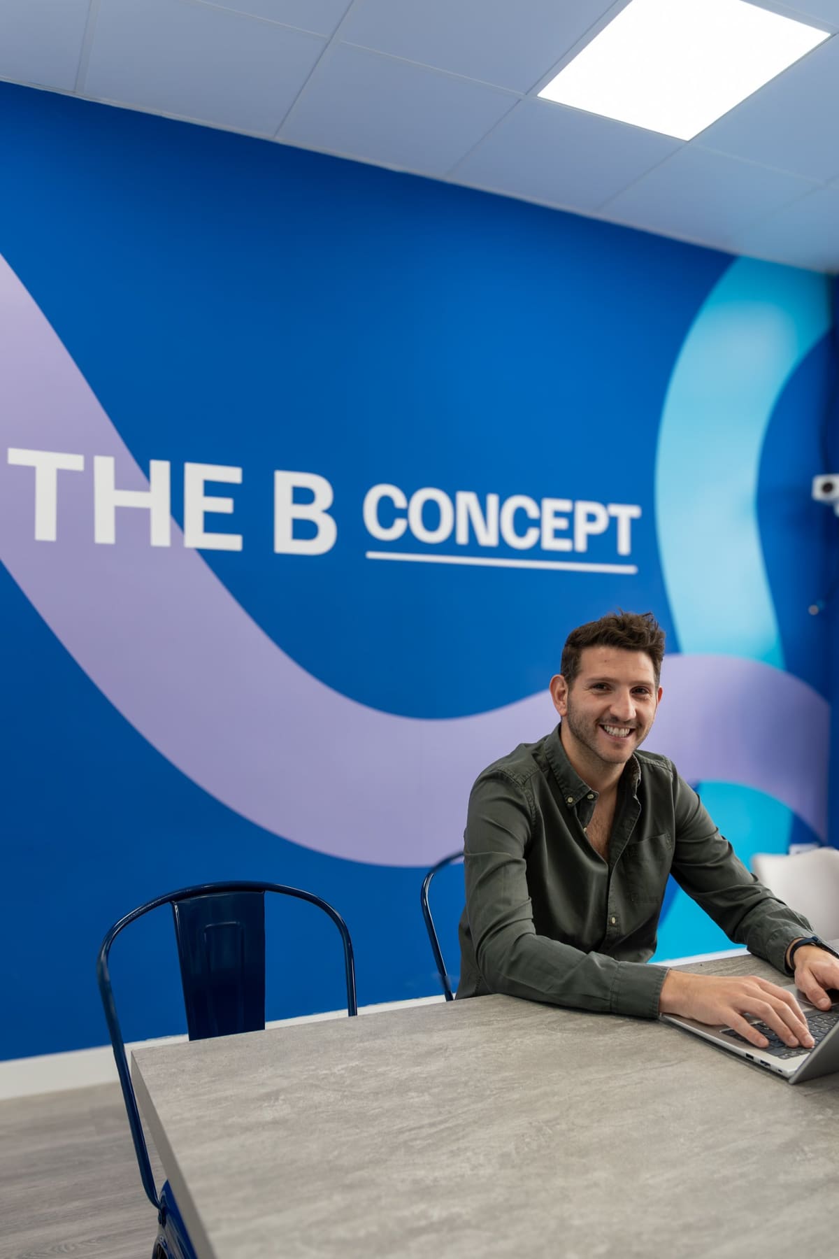 Mark Bell, fundador de The B Concept, delante de un mural